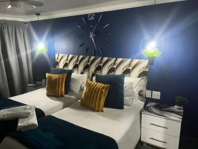 a bedroom with a large bed with a clock on the wall at Mitchell's Guesthouse in Parow