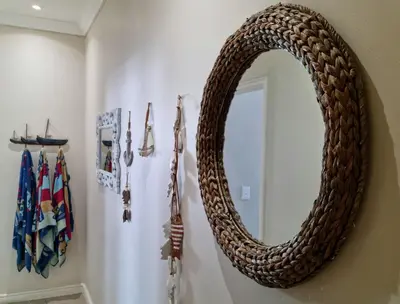 a round mirror hanging on a wall in a bathroom at 'The View' on Bikini Beach, Seafront, 2 bedroom, Sleeps 4 in Gordonʼs Bay