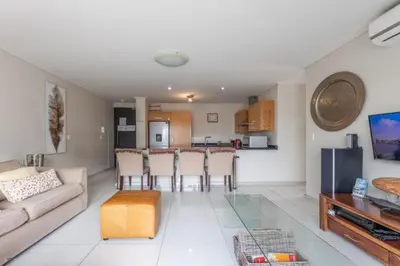 a living room with a couch and a table at Manhattan Luxury Suite at Canal Walk in Cape Town