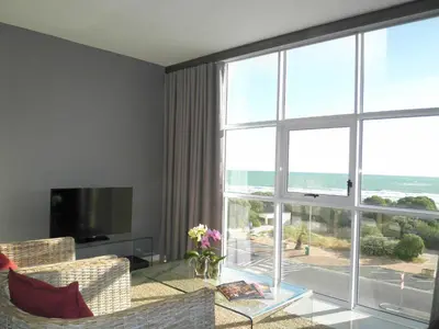 a living room with a couch and a large window at 308 St Tropez in Strand