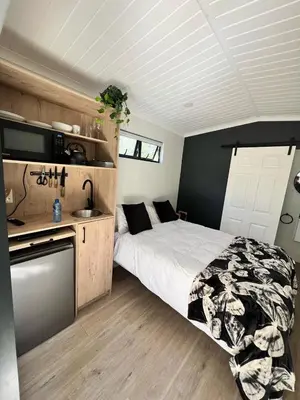 a bedroom with a bed and a kitchen with a sink at Du Kloof Lodge in Paarl