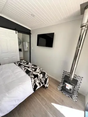 a bedroom with a bed and a fireplace and a tv at Du Kloof Lodge in Paarl