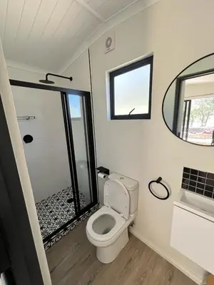 a small bathroom with a toilet and a mirror at Du Kloof Lodge in Paarl