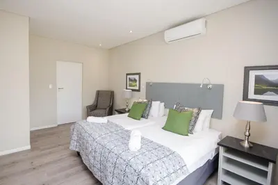 a bedroom with a large bed with green pillows at Du Kloof Lodge in Paarl