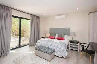 a bedroom with a bed with two red pillows at Du Kloof Lodge in Paarl