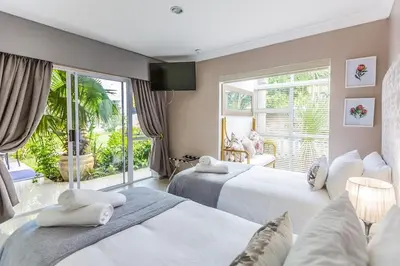 a bedroom with two beds and a large window at Hermanus Manor in Hermanus