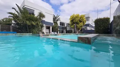 a large swimming pool with blue water in front of a building at Hermanus Manor in Hermanus