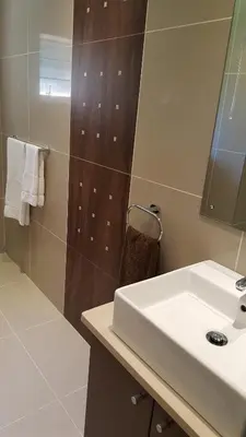 a bathroom with a white sink and a mirror at Edelweiss Bed & Breakfast in Stellenbosch