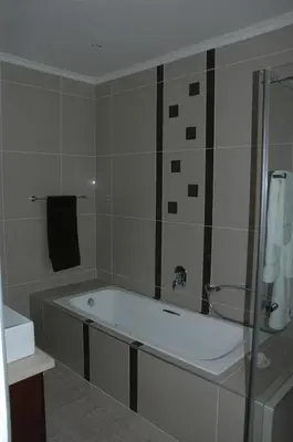a bath tub in a bathroom with a shower at Edelweiss Bed & Breakfast in Stellenbosch
