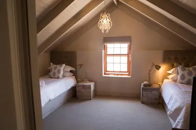 a attic room with two beds and a window at Mont d'Or Franschhoek in Franschhoek