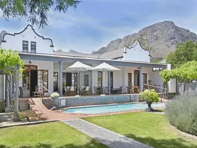 a home with a swimming pool and a house at Mont d'Or Franschhoek in Franschhoek