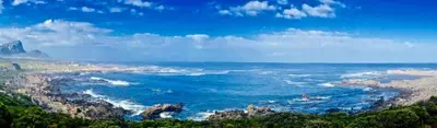 a view of the ocean with rocks and the coast at Proteus Beach House in Rooiels