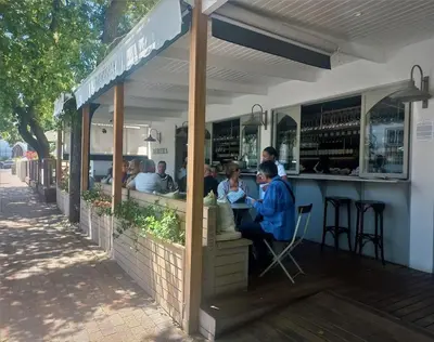 a group of people sitting at a restaurant at Concord Apartment in Stellenbosch