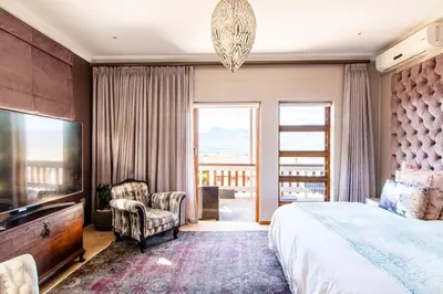 a bedroom with a large bed and a large window at A' Queenslin Guesthouse in Paarl