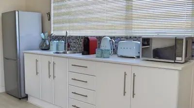 a kitchen counter with a microwave and a refrigerator at 1AA Wilhelmina Luxury Suites in Franschhoek
