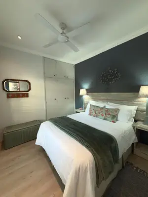 a bedroom with a large bed with a black wall at Treehouse at Theebos in Strand