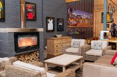 a living room with a fireplace and wicker chairs at Trail's End in Elgin