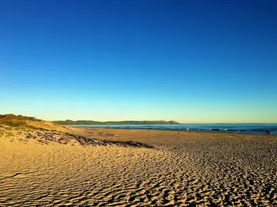 a sandy beach with the ocean in the background at The Gables Hermanus in Hermanus