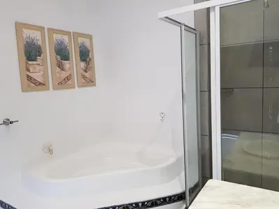 a bathroom with a tub and three pictures on the wall at Zonnevanger Guesthouse in Noorder-Paarl