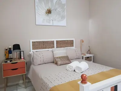 a bedroom with a bed with two towels on it at Zonnevanger Guesthouse in Noorder-Paarl