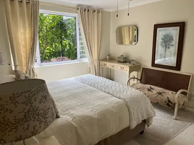 a bedroom with a bed and a window at On Broadwalk Cottage in Cape Town