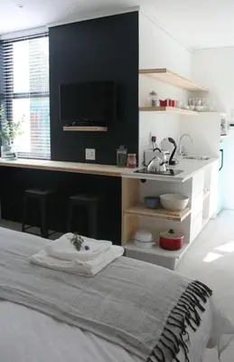 a bedroom with a bed and a desk with a sink at No. 9 Keurboom in Cape Town