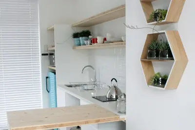 a kitchen with wooden shelves and a sink at No. 9 Keurboom in Cape Town