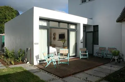 a house with a patio with chairs and a bed at No. 9 Keurboom in Cape Town