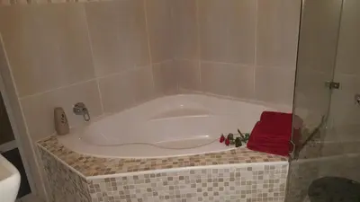 a bath tub with a red towel in a bathroom at Guest House Frame Ace in Bellville