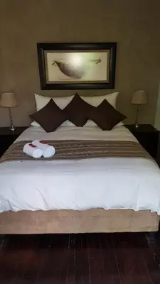 a bedroom with a bed with two slippers on it at Guest House Frame Ace in Bellville