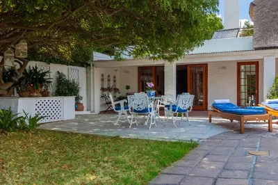a patio with chairs and a table in a yard at The Garden View Suite in Franschhoek