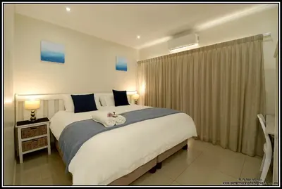 a bedroom with a large white bed in a room at Paarl Mountain Lodge in Paarl