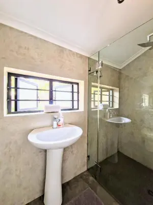 a bathroom with a sink and a glass shower at 9 on Drommedaris in Stellenbosch