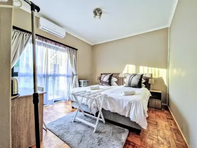 a bedroom with a bed and a large window at 9 on Drommedaris in Stellenbosch