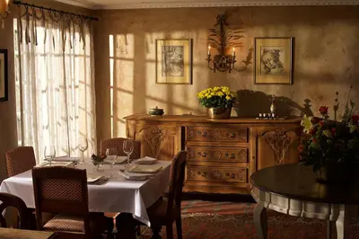a dining room with a table and a dresser at Baruch Guesthouse on Lovell in Stellenbosch