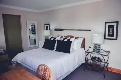 a bedroom with a bed with black and white pillows at Station House Simondium in Simondium