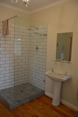 a bathroom with a sink and a glass shower at Cheverells Farm, Kiku & Braeburn Cottage in Grabouw