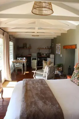 a room with a bed and a living room at Cheverells Farm, Kiku & Braeburn Cottage in Grabouw