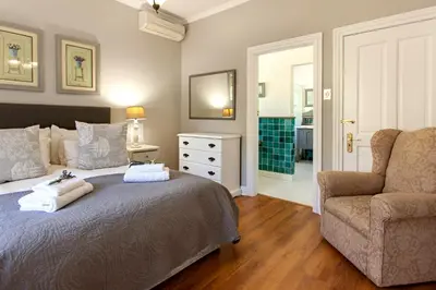 a bedroom with a bed and a couch and a chair at Summerhill Guest Farm in Worcester