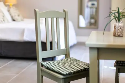 a green chair with a checkered seat sitting next to a table at Summerhill Guest Farm in Worcester