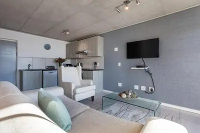 a living room with a couch and a tv on a wall at Key West 417 by CTHA in Cape Town