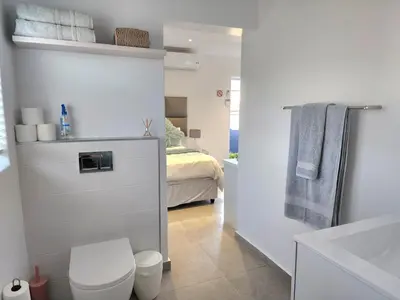 a bathroom with a toilet and a bed at Mossel 11 Studio in Bloubergstrand