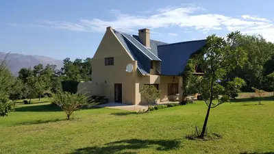 a house with a metal roof on a green field at Tuckaway in Somerset West