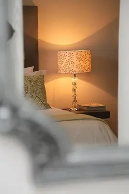 a bedroom with a bed with a lamp on a table at 5 Konings Guesthouse in Paarl