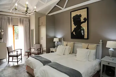 a bedroom with a large bed with white pillows at 5 Konings Guesthouse in Paarl
