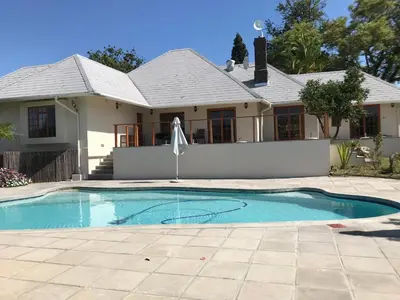 a house with a swimming pool in front of a house at Lauradale Accommodation in Stellenbosch