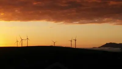 a group of wind turbines on a hill at sunset at Die Pastorie in Caledon