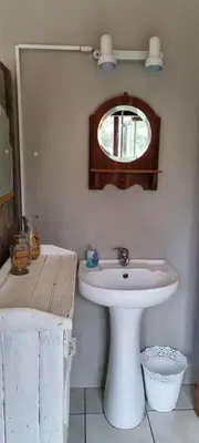 a bathroom with a white sink and a mirror at Die Pastorie in Caledon