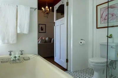 a bathroom with a bath tub and a toilet at Eastcliff Cottage in Hermanus