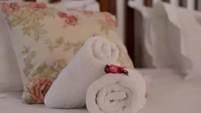 a stuffed animal is sitting on a bed at Eastcliff Cottage in Hermanus